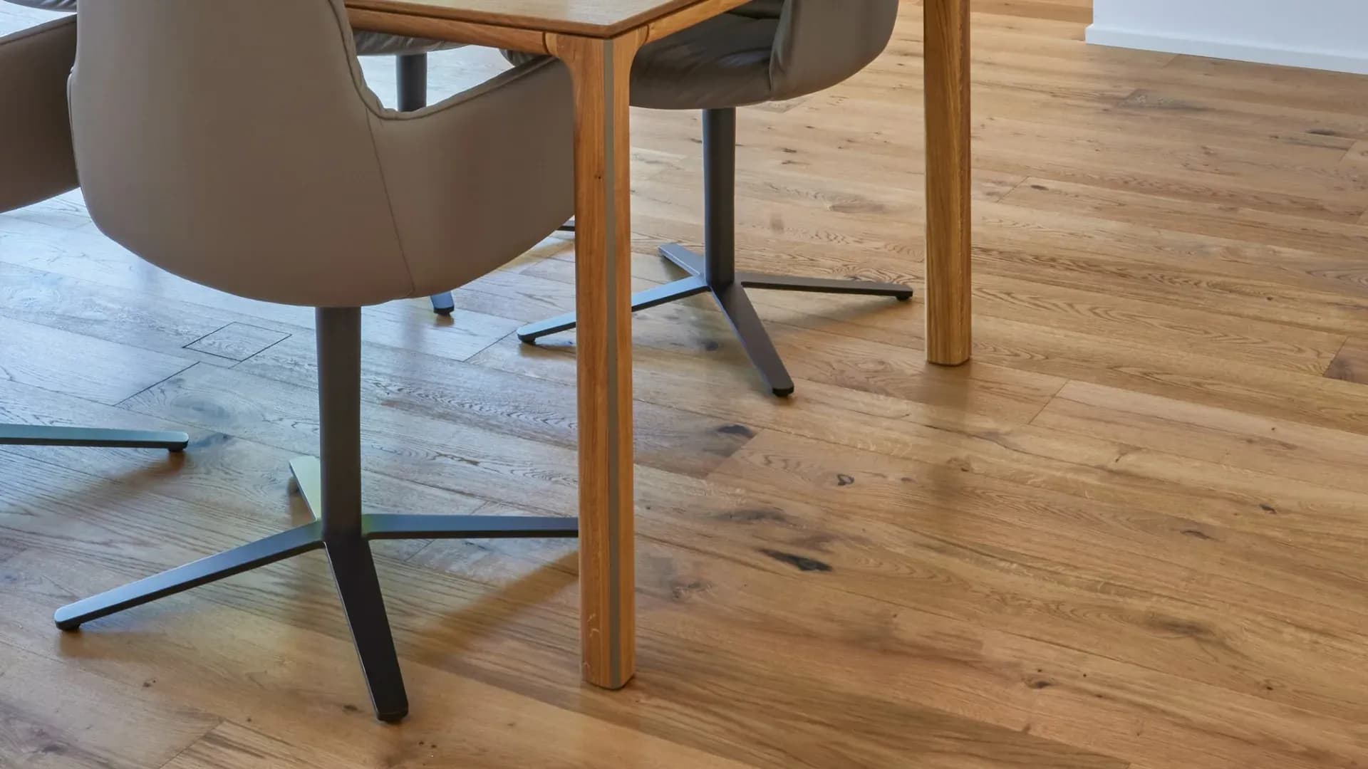 Lames de chêne huilé au veinage vivant sous une table à manger en bois et deux chaises en cuir