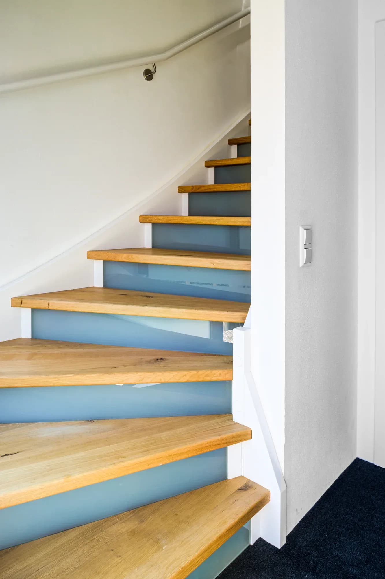 Escalier en bois massif avec marches en chêne et contremarches en verre satiné lumineux sur limon laqué blanc