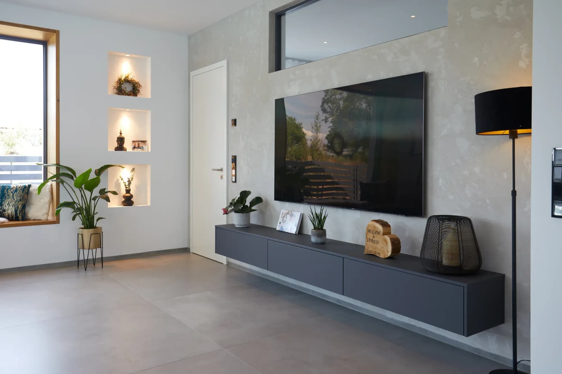 Meuble bas suspendu graphite avec niches murales éclairées dans le salon