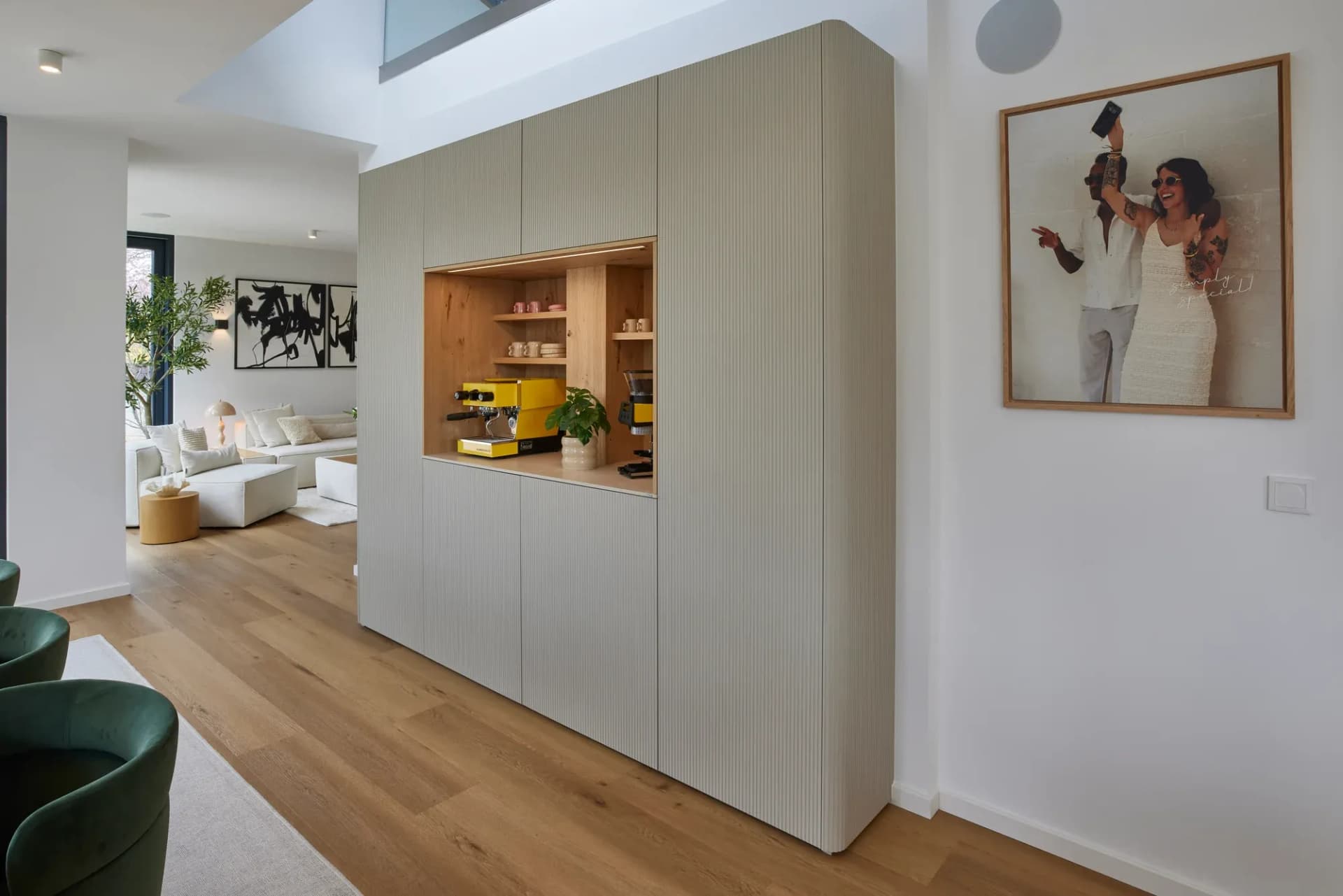 Bloc de meubles indépendant avec façades rainurées fraisées et niche ouverte en chêne, avec le salon en arrière-plan.