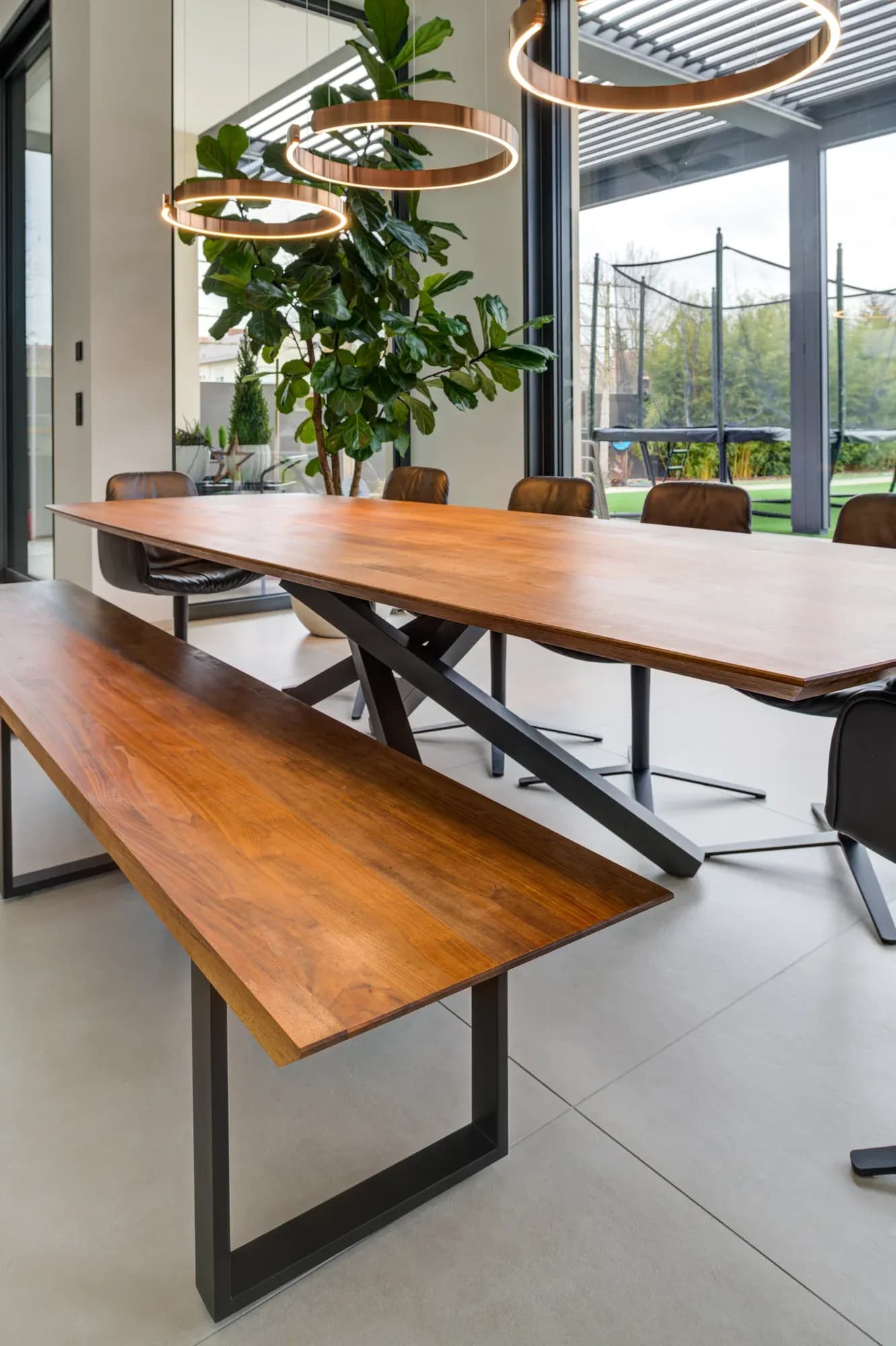 Table en bois massif à bord vivant avec banc assorti sous des suspensions circulaires