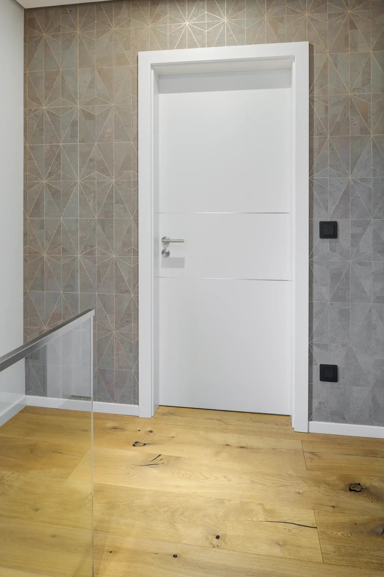 Palier supérieur avec plancher chêne rustique, garde-corps en verre et mur à motifs