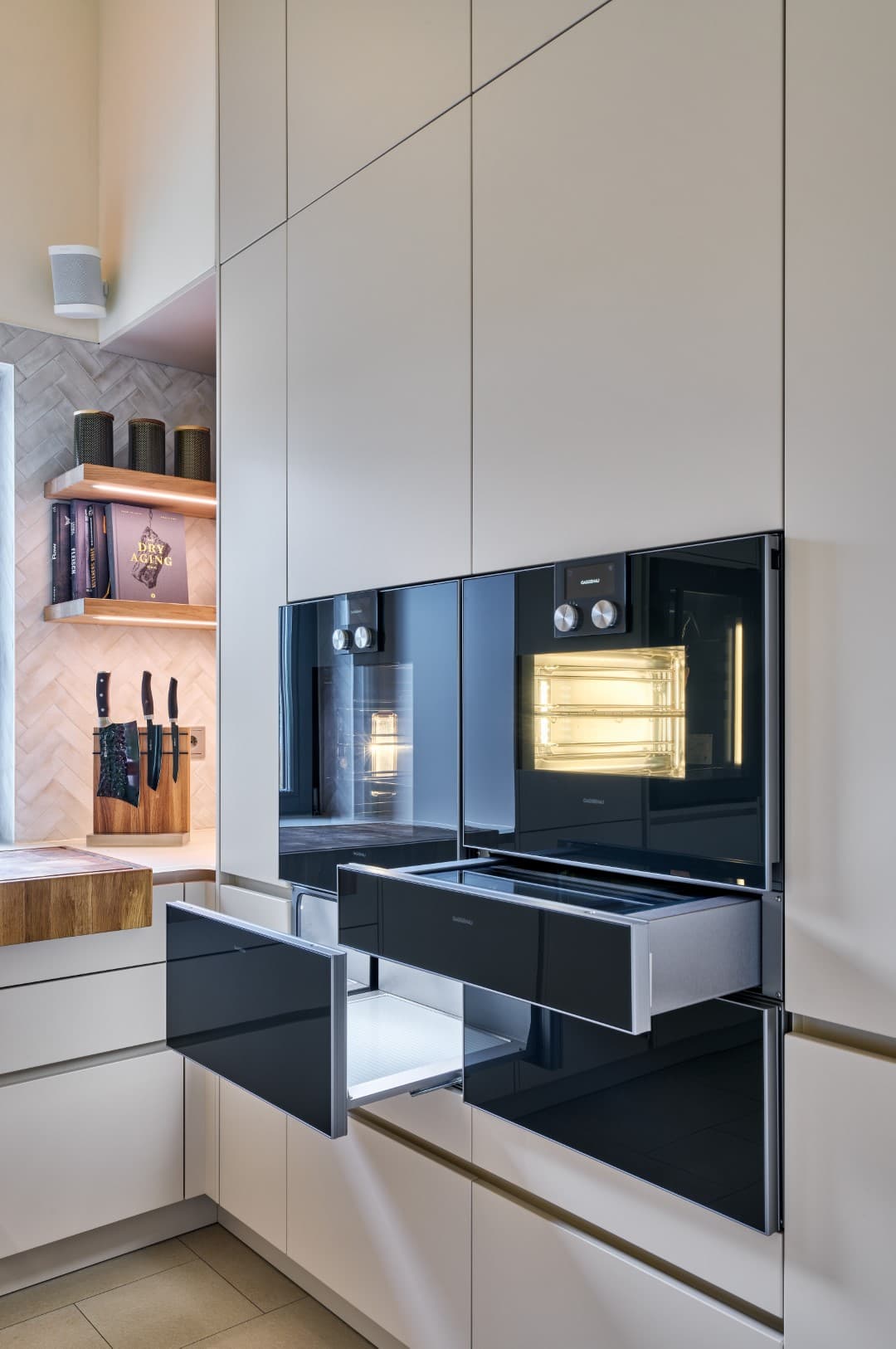 Appareils Gaggenau modernes dans la cuisine, dont un four vapeur et des tiroirs chauffants