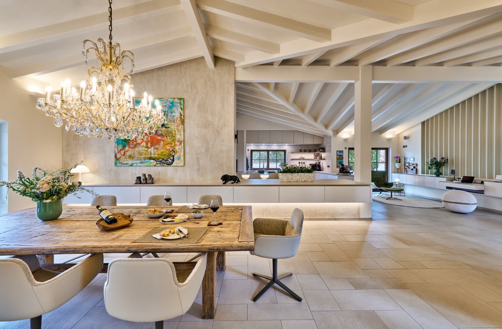 L'espace repas et la cuisine attenante dans un design harmonieux, avec une grande table en bois et des chaises modernes